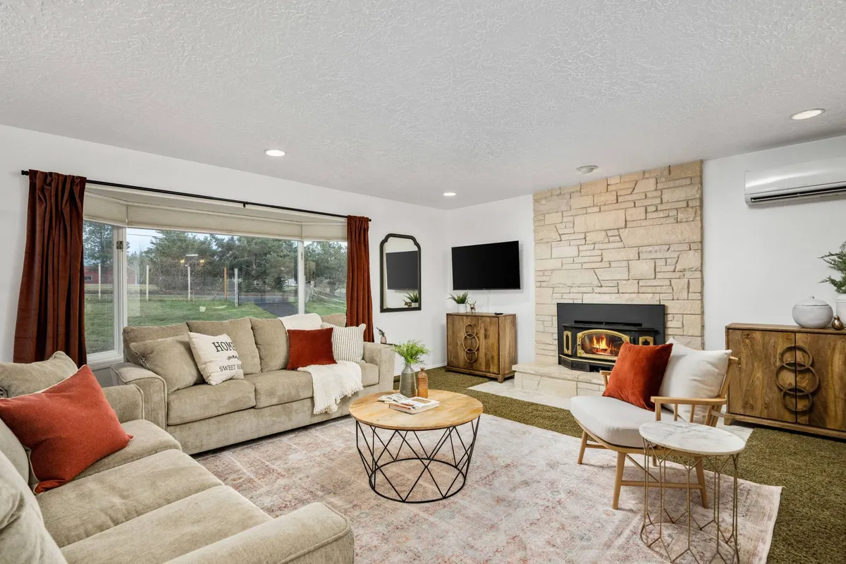 A cozy interior scene featuring a fireplace, comfortable sofa, coffee table, window, and a TV. The space is arranged for group relaxation, socializing, and entertainment, evoking evenings spent together or game nights with family.